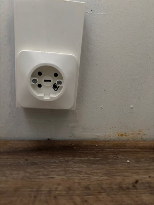 Vägguttag för köksspis med vit ram monterat på vägg.