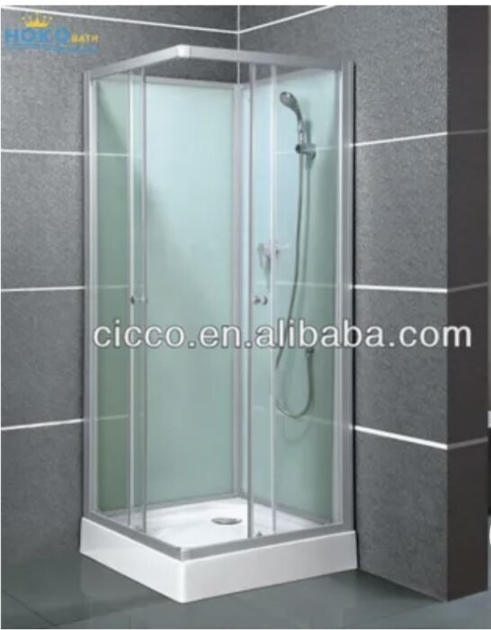 Duschkabin med transparenta glasväggar och silverfärgad ram mot grå kakelvägg; duschmunstycke syns innanför kabinen.