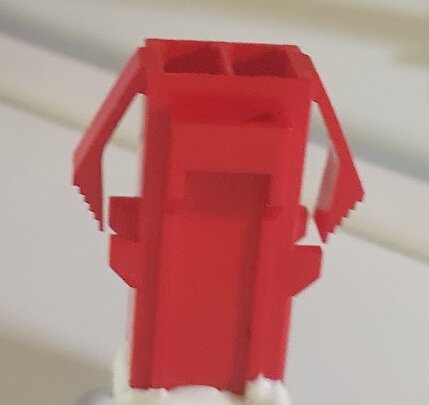 Röd kontakt för att ansluta en LED-lampa till frysens el-matning, visas närbild.