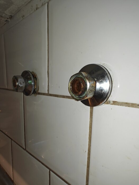 Väggmonterad köksarmatur med avlägsnad blandare, kvarvarande metalldelar på kaklad vägg.