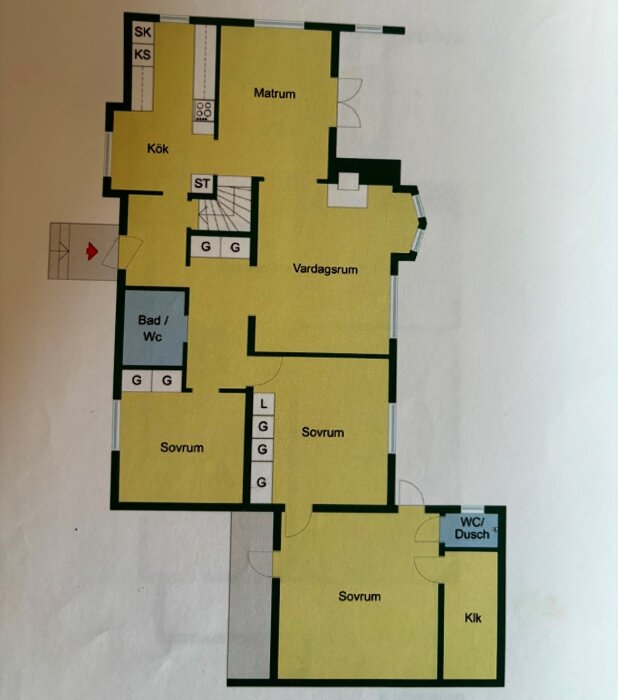 Planskiss över ett hus med kök, matrum, vardagsrum, badrum och flera sovrum, där väggen mellan kök och matrum är markerad.
