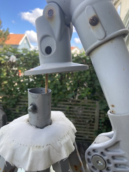 Hängparasoll med synlig lina i mitten, stång och led i närbild.