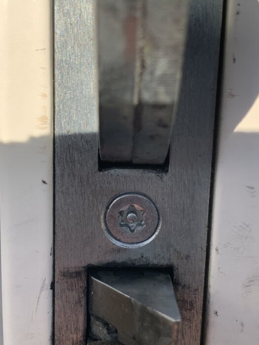 Skruv på ett låshus från ett Yale-lås med en ovanlig skruvtyp som är svår att lossa utan rätt bits.