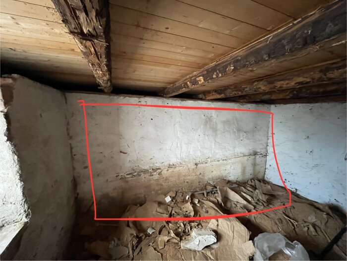 Murad vägg i källare med röd ruta markerad, visar potentiellt bärande struktur som diskuteras för rivning i stockhus från 1945.