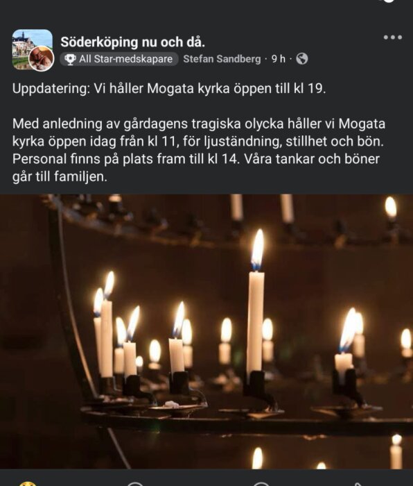 Tända ljus i en kyrka på en ljusstake i en mörk miljö.