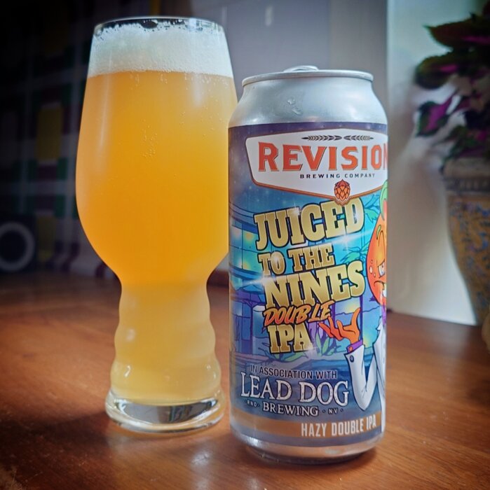 En ölburk med texten "Juiced to the Nines Double IPA" bredvid ett fyllt glas öl.