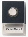 Dörrklocka av märket Friedland med svart kant och vit knapp.