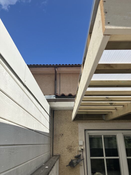 Kanalplasttak ovanför altan, där takets långsida går i linje med ramen; fråga om bästa sätt att fästa hängränna på långsidan.