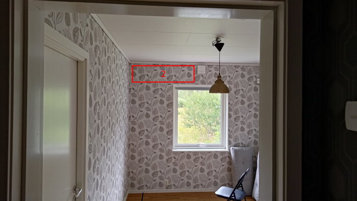 Rum med blommig tapet, fönster och lampa. Markering för LP placering i mellanrum (Plats 2).