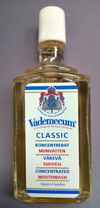 Flaska med Vademecum Classic koncentrerat munvatten med etikett på flera språk inklusive svenska, finska och engelska, tillverkat i Sverige.