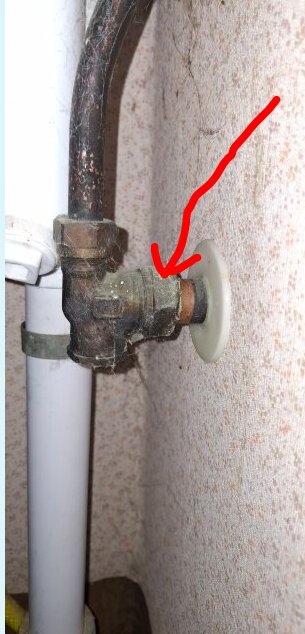 Rörkoppling med mutter vid vägg; rött streck markerar muttern för demontering.