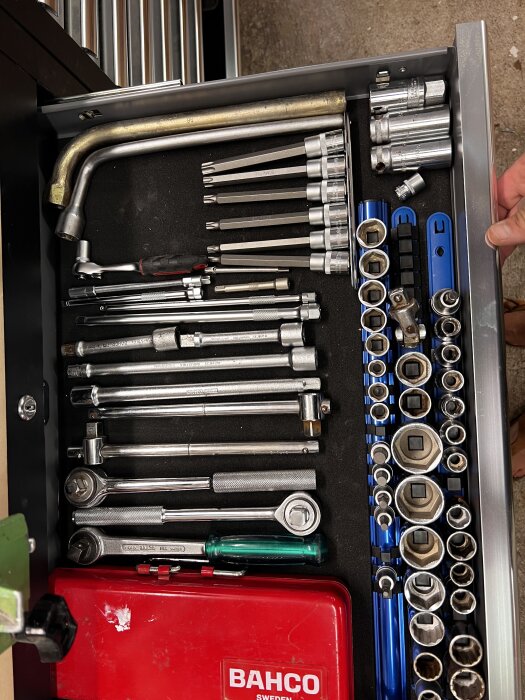 En organiserad verktygslåda med hylsnycklar, skruvmejslar och ett rött BAHCO-fodral, sett uppifrån.