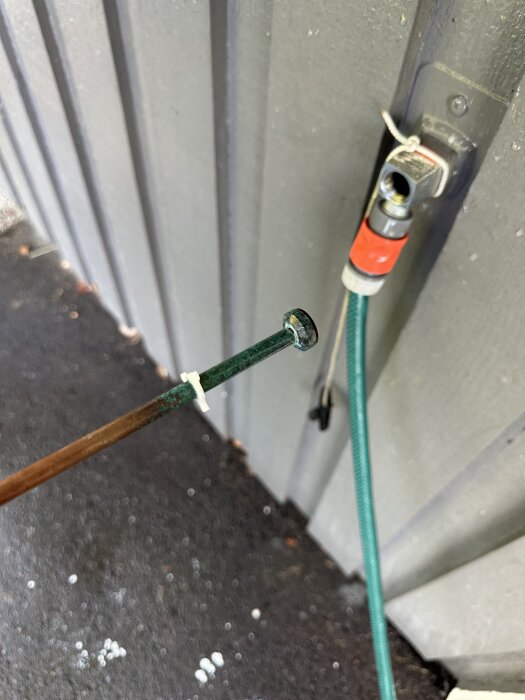 Frostsäkert vattenutkast helt utskruvat från väggen med grön slang, stänger ej av vattnet korrekt. Problem med montering.