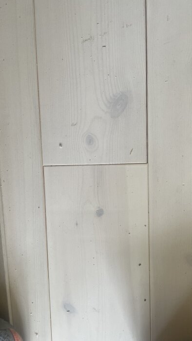 Massivt furugolv med synliga skador och ojämna glipor mellan brädorna.