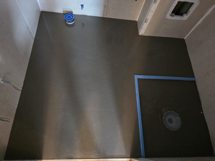 Våtrum med flytspacklat golv, blå avstängningslist runt golvbrunn, för att kontrollera flödet och skapa korrekt lutning vid renovering av badrum.