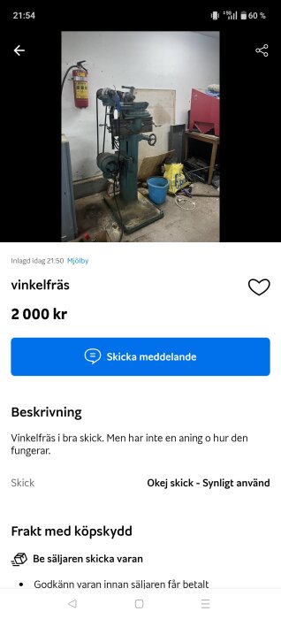 Vinkelfräs i en verkstad med brandsläckare på väggen och olika föremål som en hink och en plastpåse på golvet.