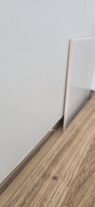 Ojämnt mellanrum mellan en ny bänkskiva och en skev vägg i ett kök, visar byggproblem med anpassning.