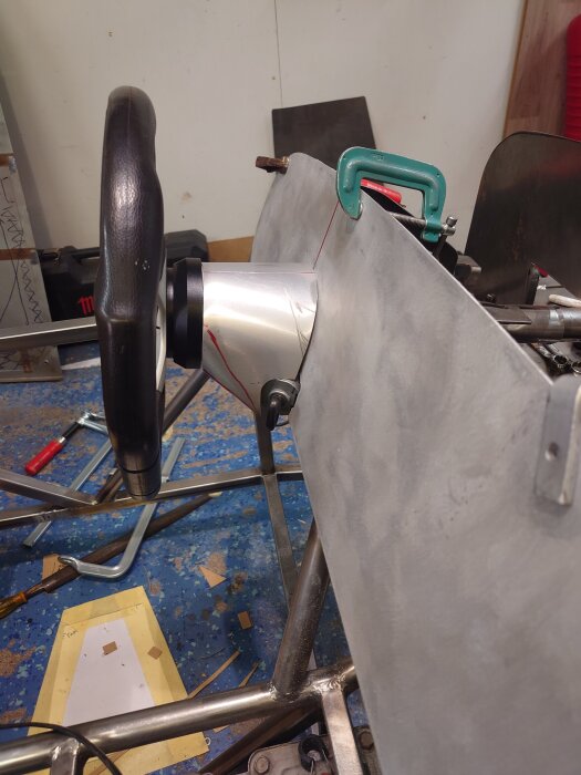 Ratt och instrumentpanel monterade på metallram med tving i verkstad.