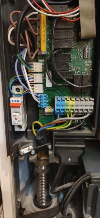 Elcentral med inkommande faser och kopplingsplintar, flera kablar anslutna samt en strömbrytare märkt Eaton.