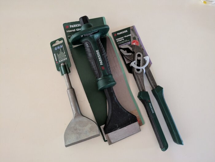 Verktyg från Lidl: en skrapa, en handmejsel och en polygriptång med gröna handtag.