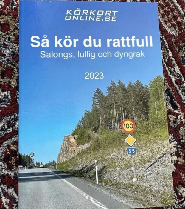 Bokomslag med texten "Så kör du rattfull" och en landsväg med hastighetsskyltar i bakgrunden.