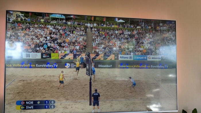 EM-final i beachvolleyboll mellan Sverige och Norge, spelare uppställda, publik i bakgrunden.