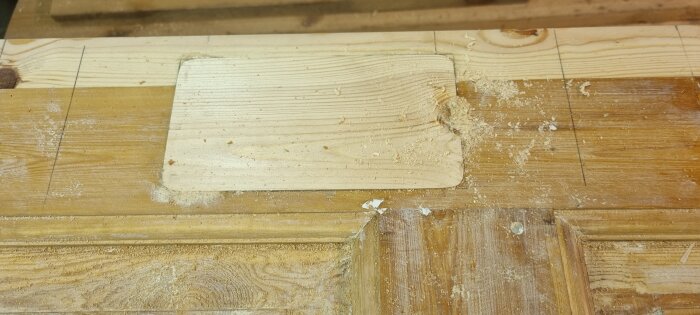 En gammal dörr som förbereds för att bli en sänggavel, med ifyllt låshål och sågspån.