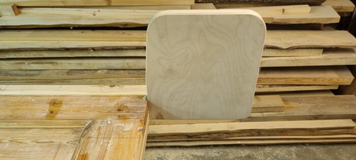 Gamla dörrar omvandlas till sänggavel, med trästycken lagda på varandra i ett snickeri, visar en påbörjad konstruktion.