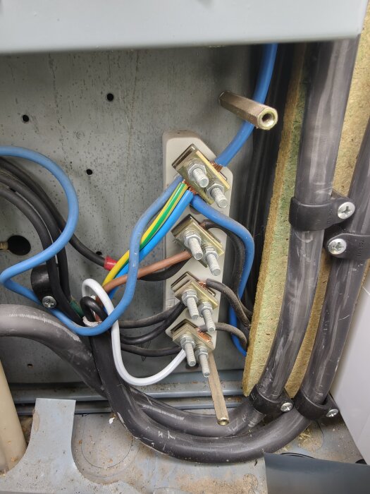 Elinstallation med flera kablar och anslutningar, möjligen ett fel, synlig felinstallation av kablar och fästelement.