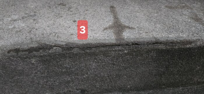 Spricka i trappsteg av betong markerat med en röd etikett med siffran 3.