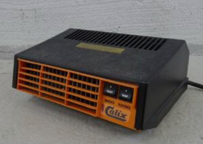 Svart och orange bilvärmare från Calix, med två effektlägen markerade som 900W och 1200W, fotograferad mot en vit vägg.