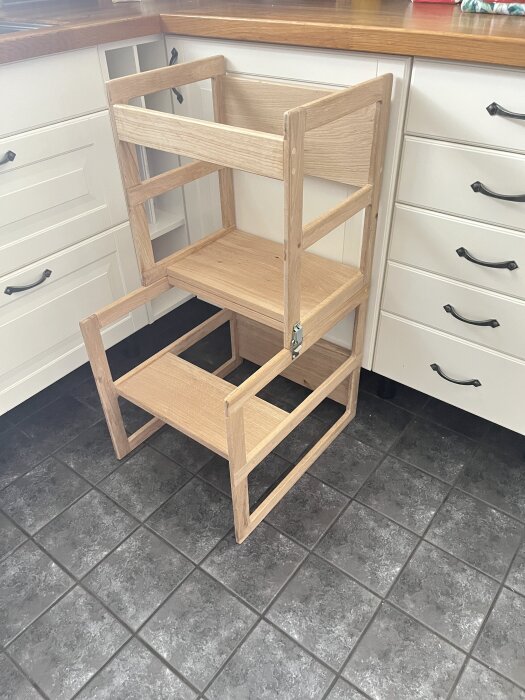 Träpall och ritbord i kök, oljebehandling planerad; hemmabygge med skavanker.