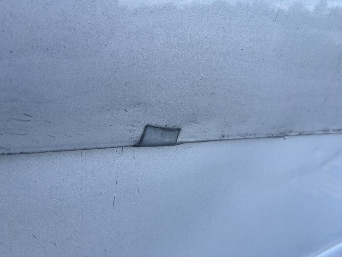 Bilden visar närbild på en takplåt med bockade fästen, använd för att identifiera vattenläckage mellan sektioner.