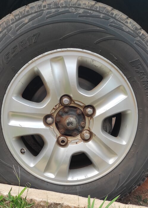 Närbild på en Toyota Land Cruiser-hjul på parkering, sedd från sidan med fälgens detaljer synliga.