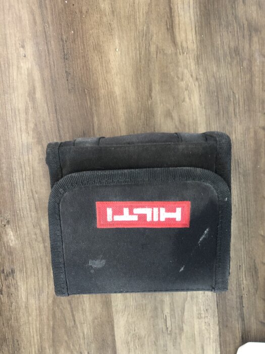 Svart fodral med Hilti-logga mot trägolv, relaterat till försäljning av grön laser Hilti PM 2LG.