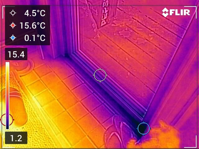 Värmekameraavbildning av altandörr som visar temperaturskillnader; kallare områden nära golv och dörrens nedre karm indikerar potentiell isoleringsbrist.