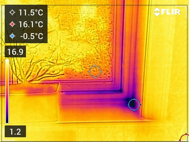 Värmebild som visar temperaturvariation kring ett fönster; kallare områden är markerade och temperaturen visas i olika färger med fokus på sik förvisande möjl. otätningar.