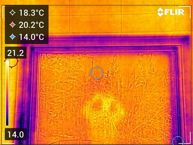 Värmebild av ett fönster med temperaturer mellan 14°C och 21.2°C. Visar möjliga isoleringsbrister mellan fönsterbladen och karmar.