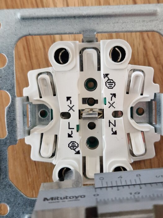 Närbild av ett Schneider Exxact tvåvägsuttag med en skjutmått som mäter kontaktyteavståndet.