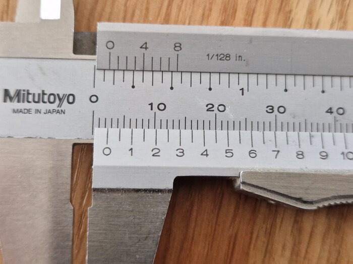 Vernierkaliper mäter kontaktyteavstånd på Schneider Exxact uttag, visar drygt 2,5 mm avstånd. Mätinstrument av märket Mitutoyo syns.