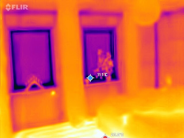 Termografisk bild av två fönster, nyinstallerade 2022, visar temperaturskillnader i november med lägsta temperaturen 11,1°C.