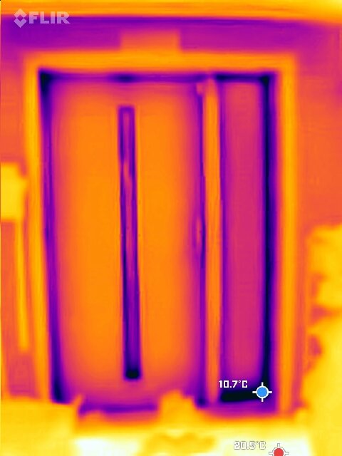Termisk bild av en dörr, visar värmeskillnader runt dörrkarm och tröskel med temperaturmätning i Celsius, tagen i slutet av november.