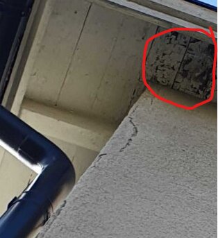 Takfot med slitna brädor, en del markerad med röd cirkel för skadetillstånd.