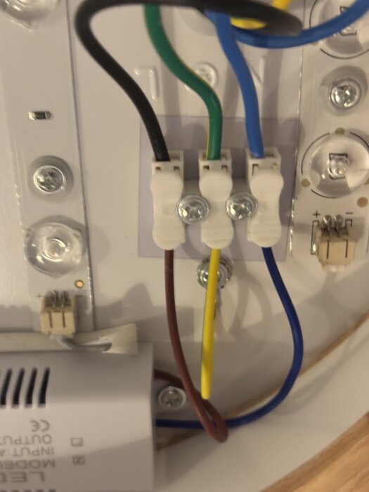 Elektriska kablar i olika färger anslutna i en kopplingsplint på en elektrisk enhet.