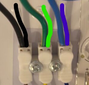 Elektrisk kopplingsplint med anslutna svarta, gröna och blå ledningar.