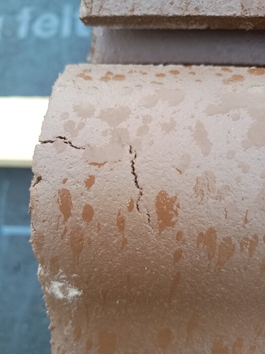 Sprucken takpanna med tillverkningsdefekter och vattendroppar, som kan leda till frostsprängning enligt beskrivning från byggforum.