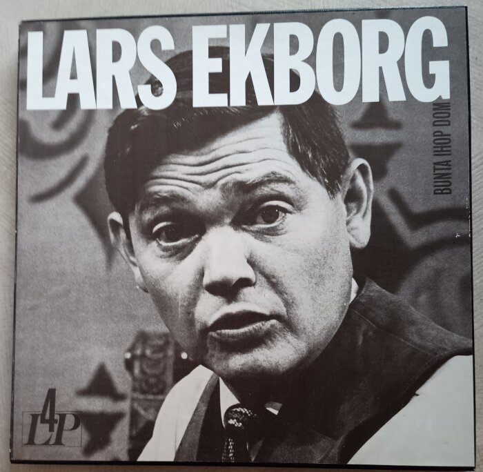 Svartvitt foto på omslaget av en Lars Ekborg-skiva, "Bunta ihop dom", där han framträder i närbild med allvarlig min.