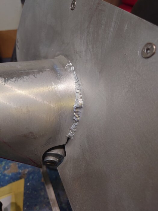 Svetsfog och fastsvetsade muttrar på metallplåt, visar ett steg i ett byggprojekt.