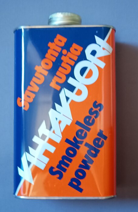 Blå och orange krutflaska med texten "Smokeless powder".
