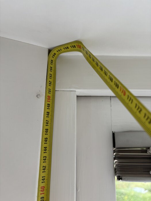 Mätband mot vit vägg och fönsterkarm, visar måtten 140-160 cm.